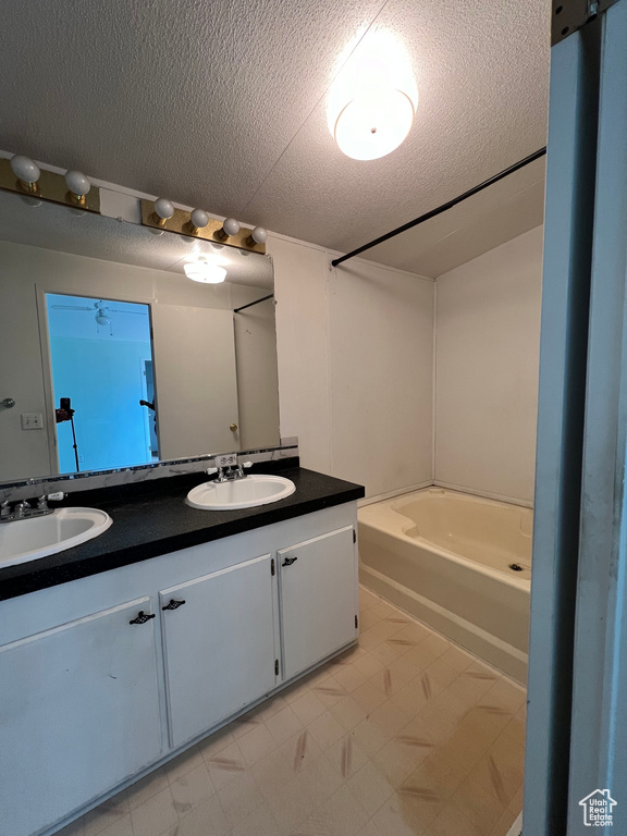 Bathroom featuring a textured ceiling and vanity