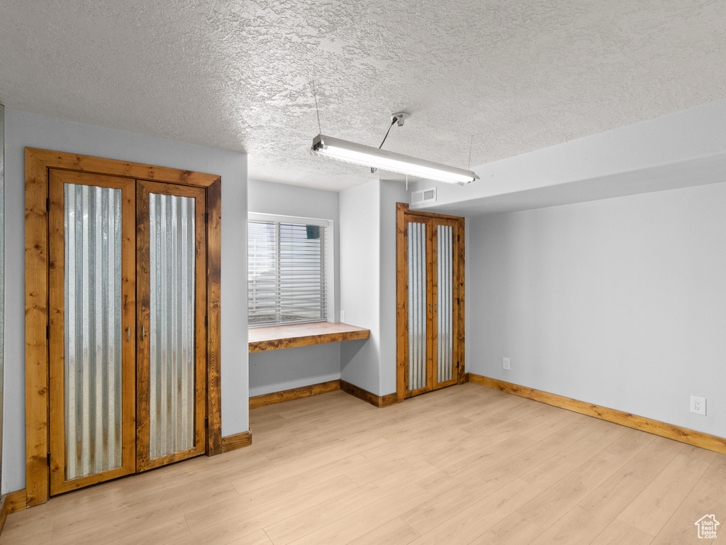 Interior space with light hardwood / wood-style flooring and a textured ceiling