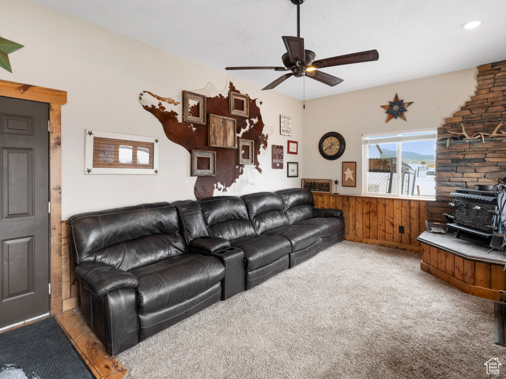 Living room featuring carpet, ceiling fan, and wood walls