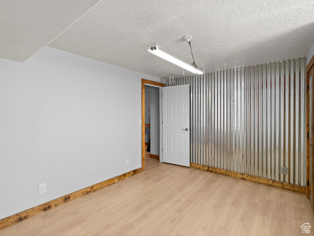 Spare room featuring light hardwood / wood-style flooring and a textured ceiling