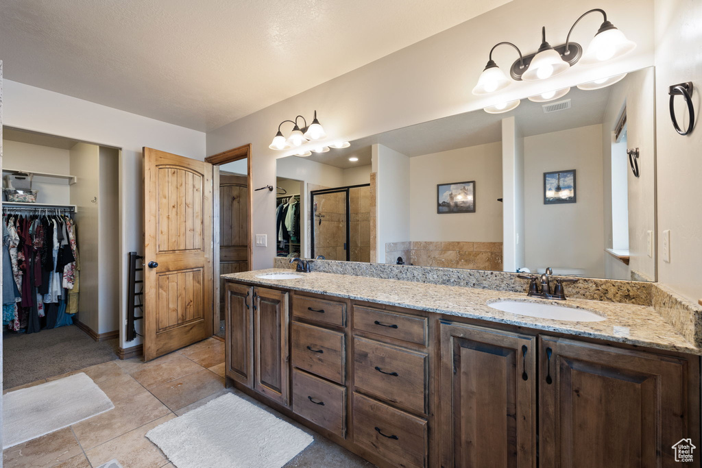 Bathroom with tile patterned flooring, vanity, and an enclosed shower