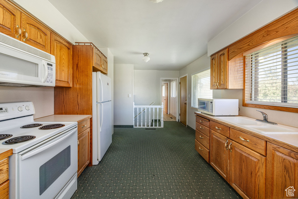 Kitchen featuring sink and white appliances