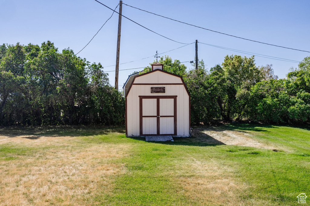 View of outbuilding featuring a lawn