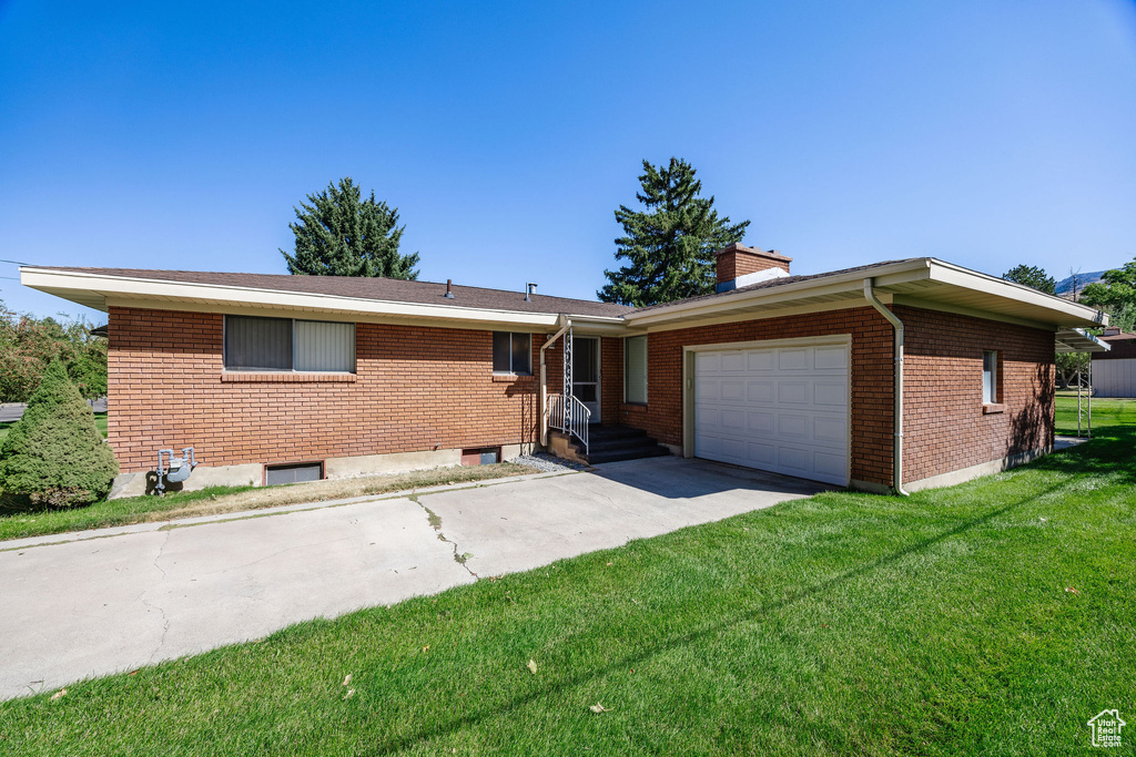 View of front of home featuring a front yard and a garage