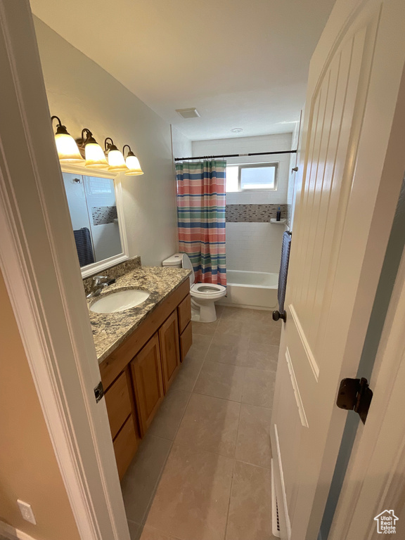 Full bathroom with shower / bath combo with shower curtain, tile patterned flooring, toilet, and vanity