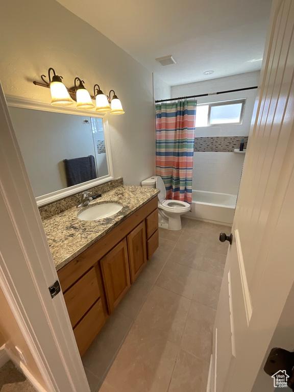 Full bathroom with vanity, toilet, shower / tub combo, and tile patterned floors