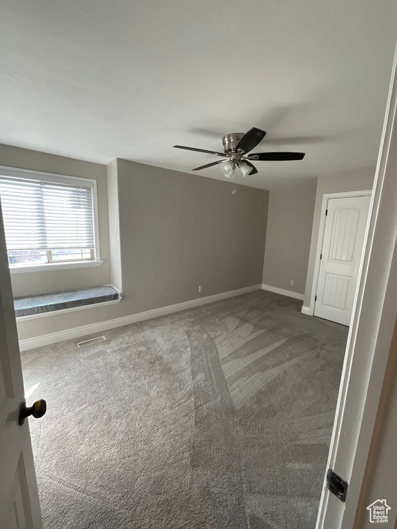 Carpeted spare room with ceiling fan