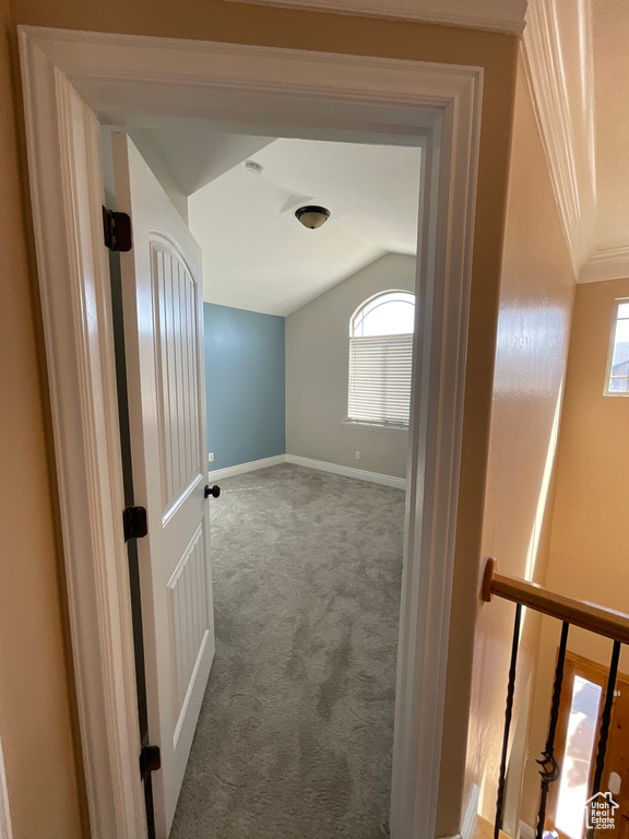 Corridor with lofted ceiling and carpet