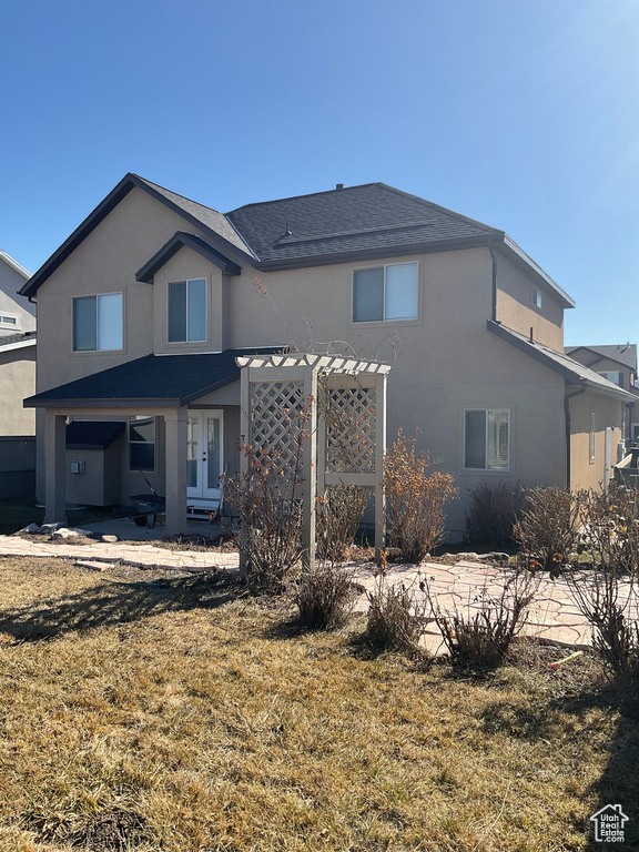 View of front of home with a front yard and a pergola