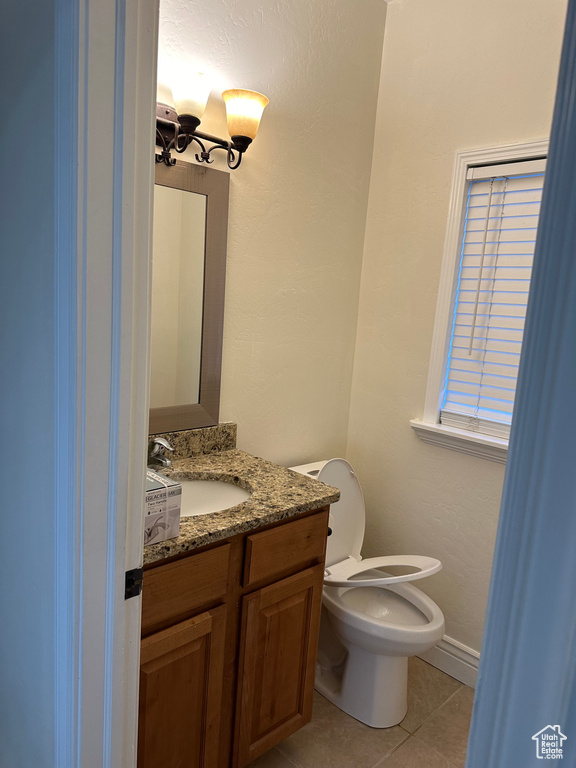 Bathroom featuring tile patterned flooring, vanity, and toilet