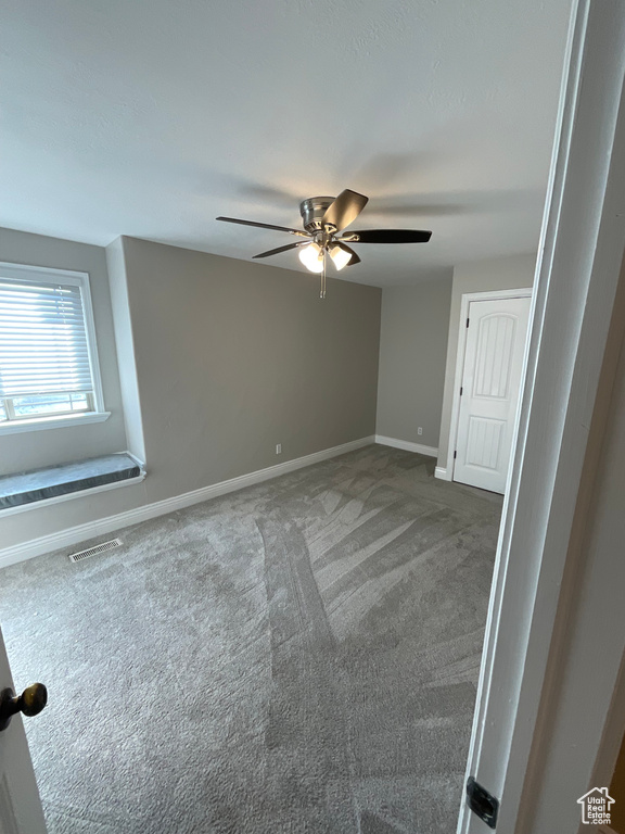 Empty room with ceiling fan and carpet