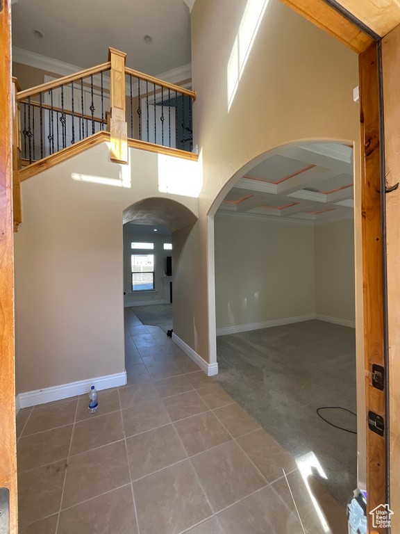 Interior space featuring coffered ceiling, beam ceiling, and a high ceiling