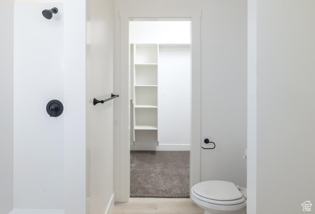 Bathroom with toilet and hardwood / wood-style flooring