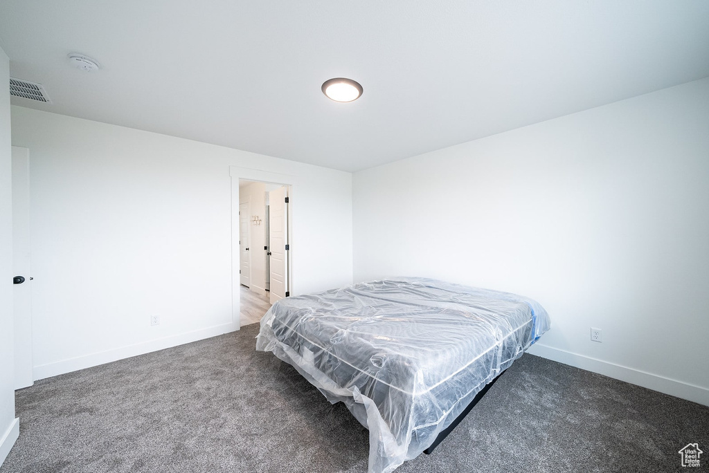 Bedroom featuring dark carpet