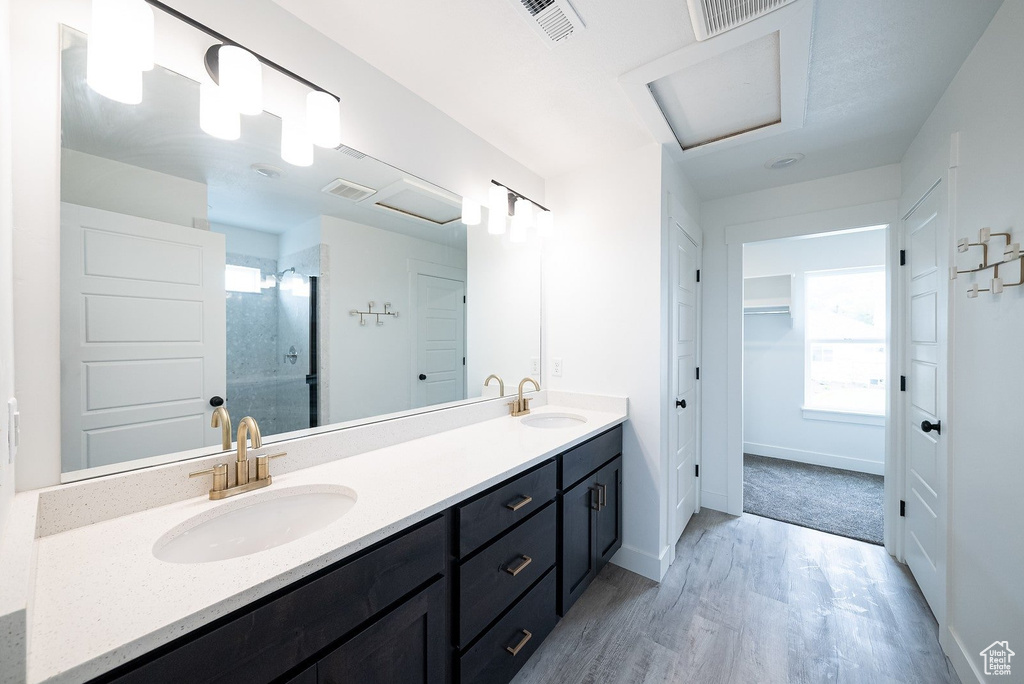 Bathroom with vanity, wood-type flooring, and an enclosed shower