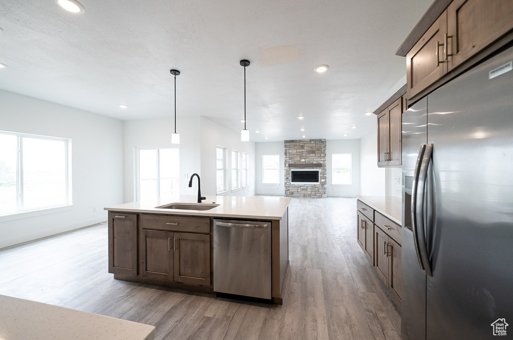 Kitchen with pendant lighting, stainless steel appliances, a wealth of natural light, and sink