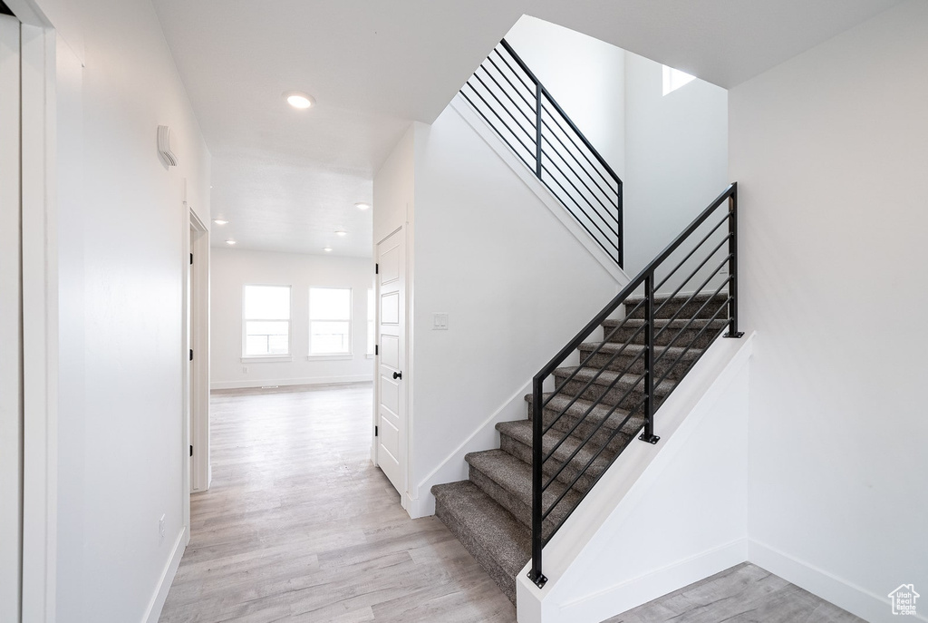 Stairs featuring hardwood / wood-style flooring