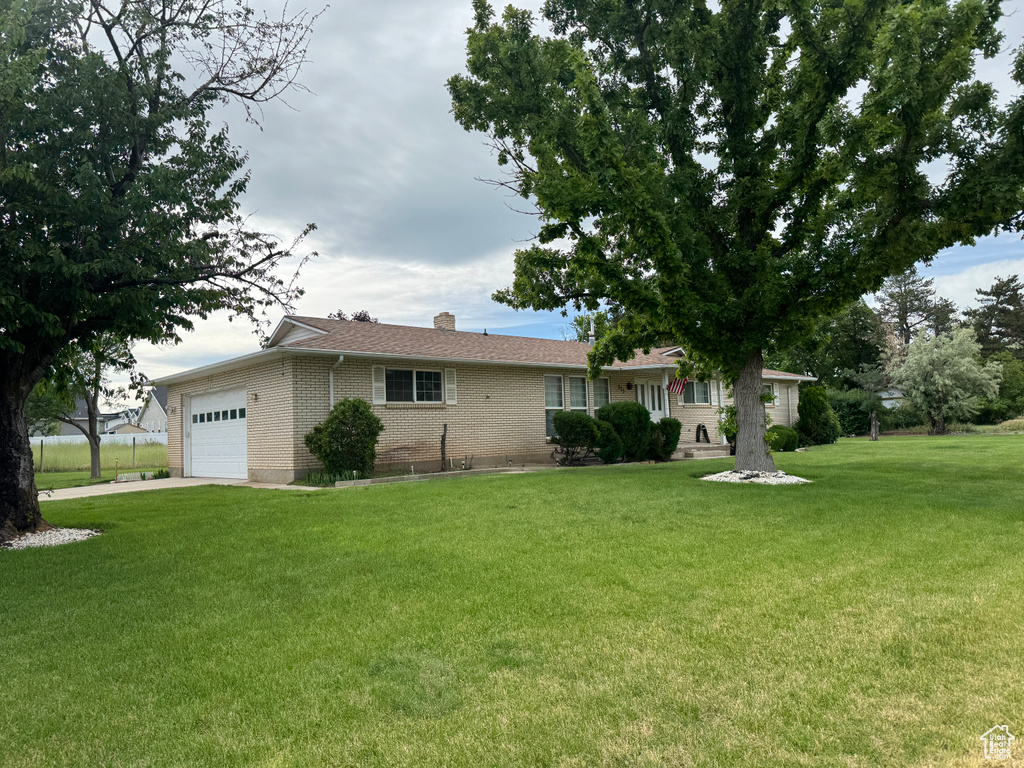 Ranch-style home with a front lawn and a garage