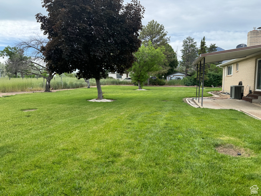 View of yard featuring central AC unit and a patio area