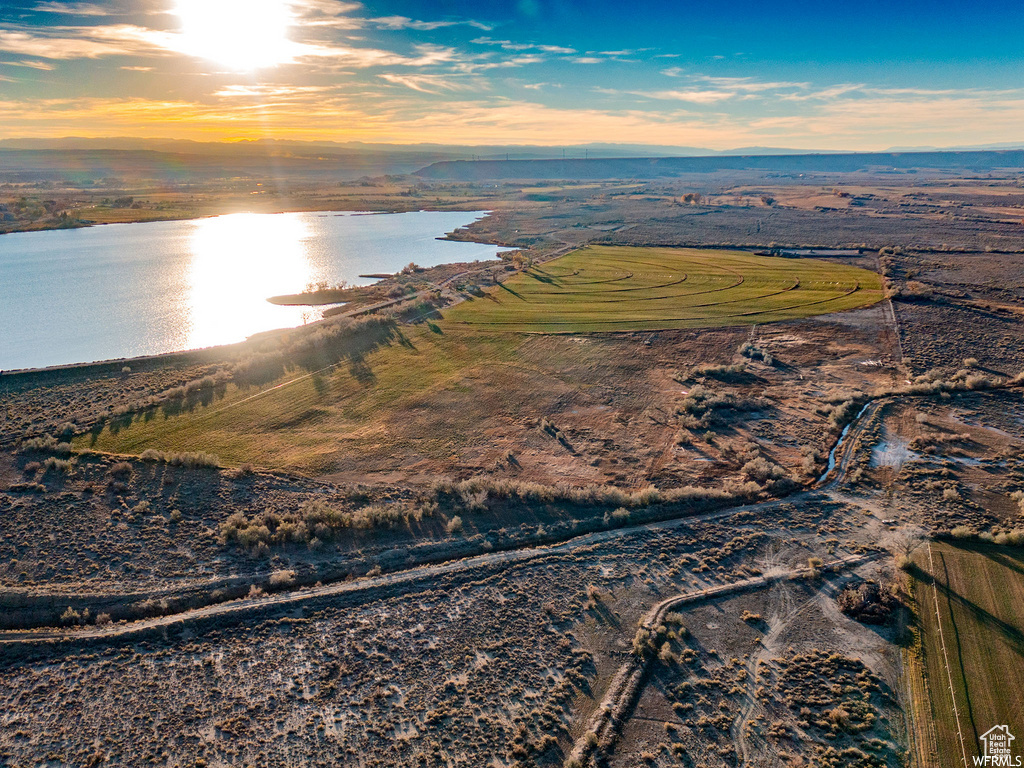 Aerial view at dusk featuring a water view and a rural view