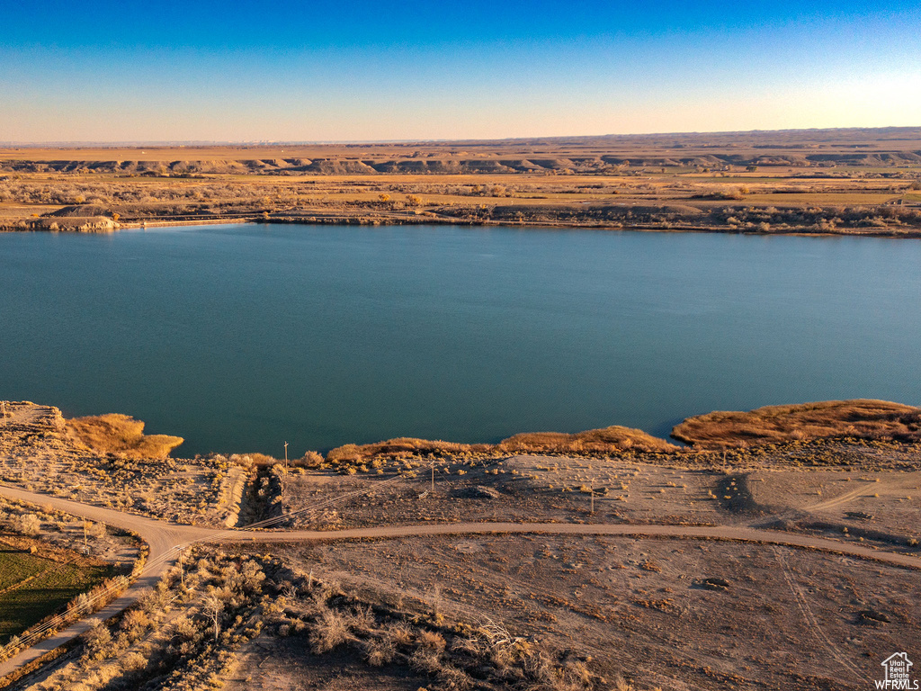 Aerial view at dusk featuring a water view