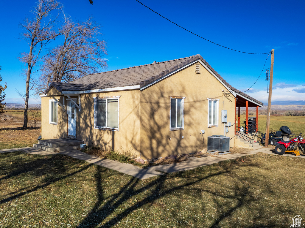 View of home's exterior with a patio, a yard, and central air condition unit