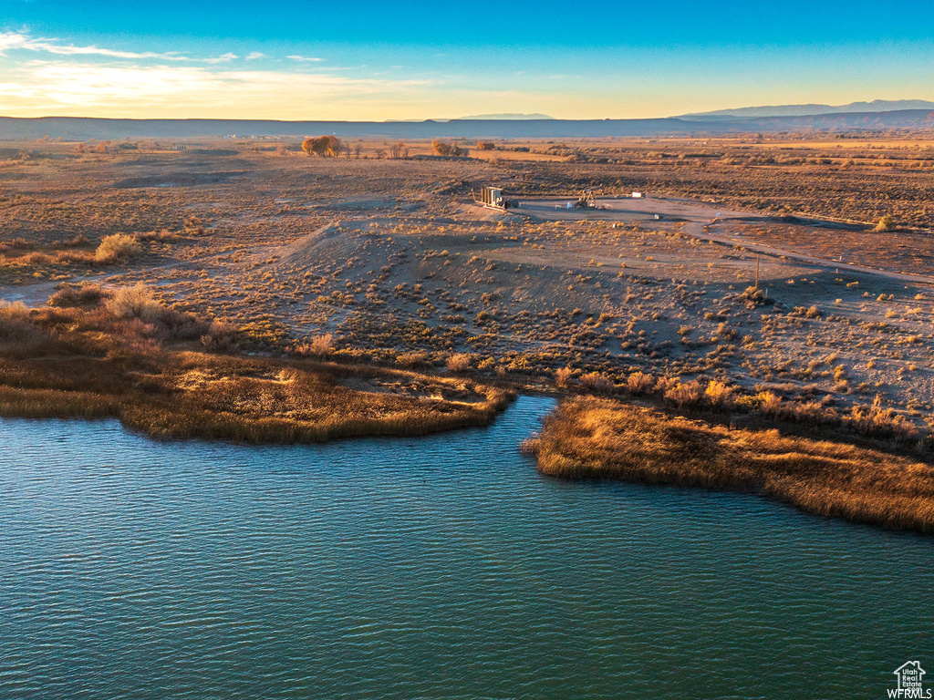 Aerial view at dusk featuring a water view