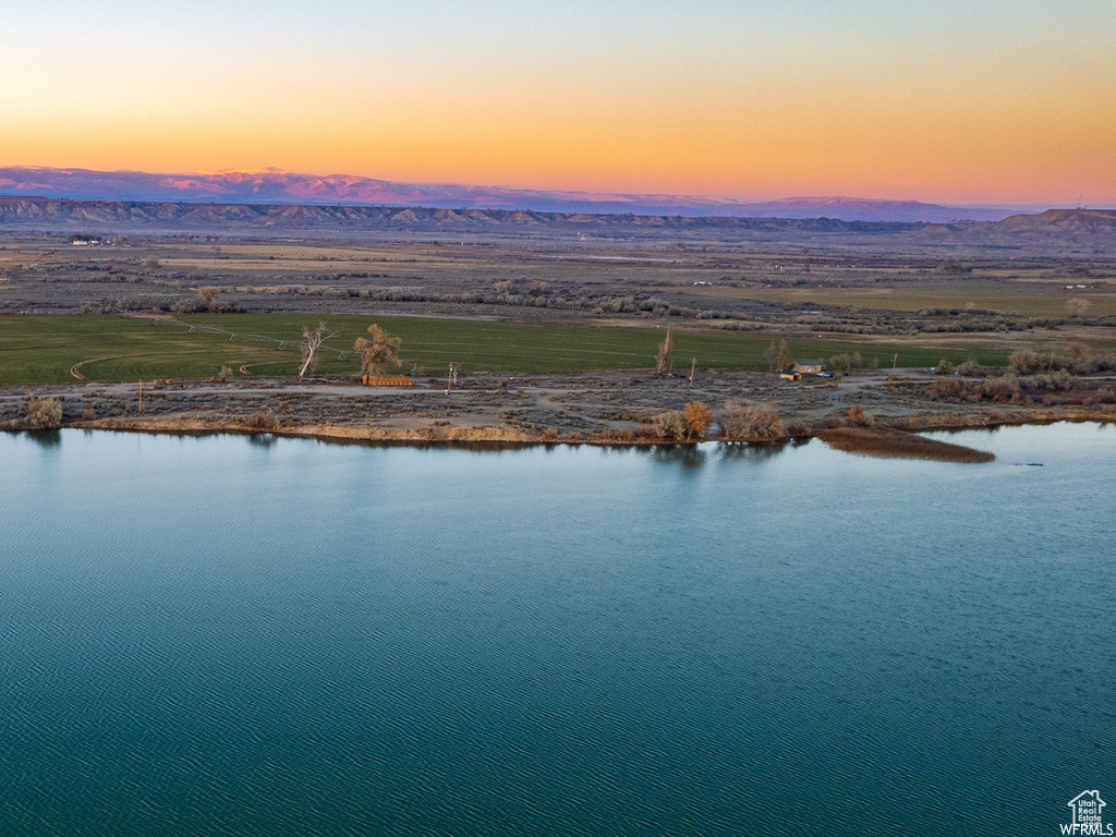 Aerial view at dusk featuring a water and mountain view