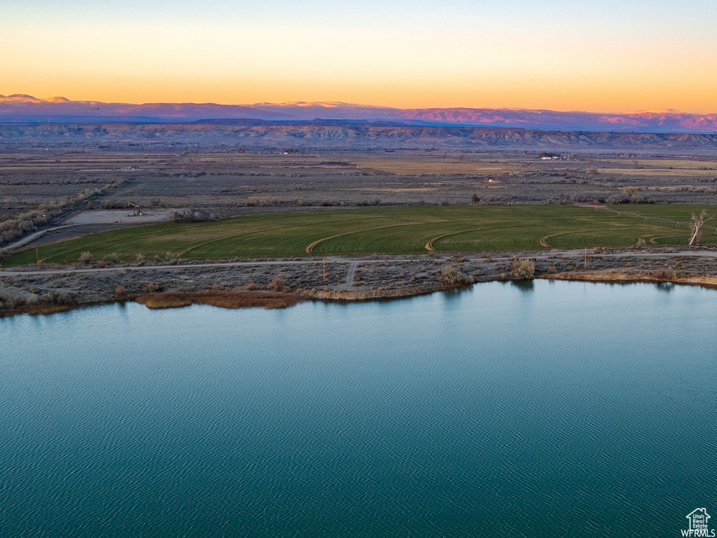 Aerial view at dusk featuring a water and mountain view