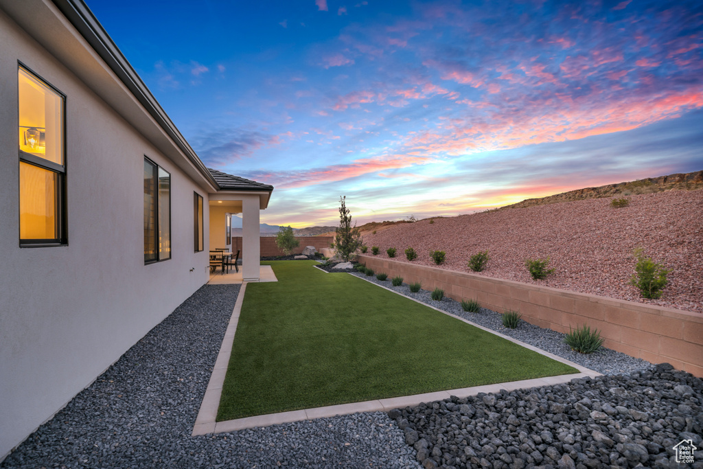 Yard at dusk with a mountain view and a patio area