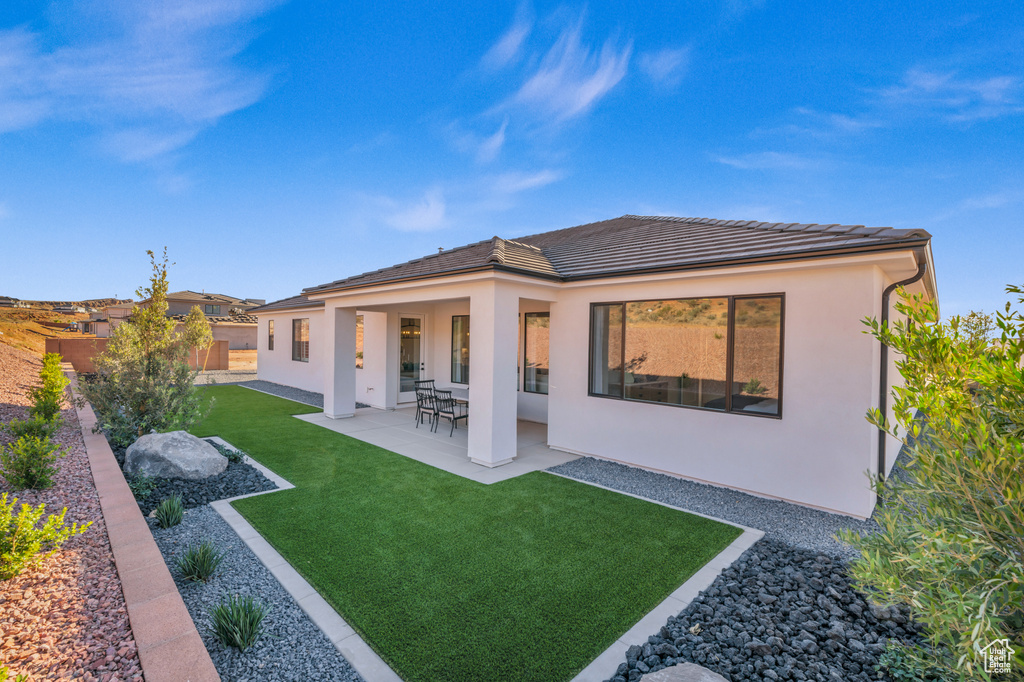 Back of property featuring a patio and a yard