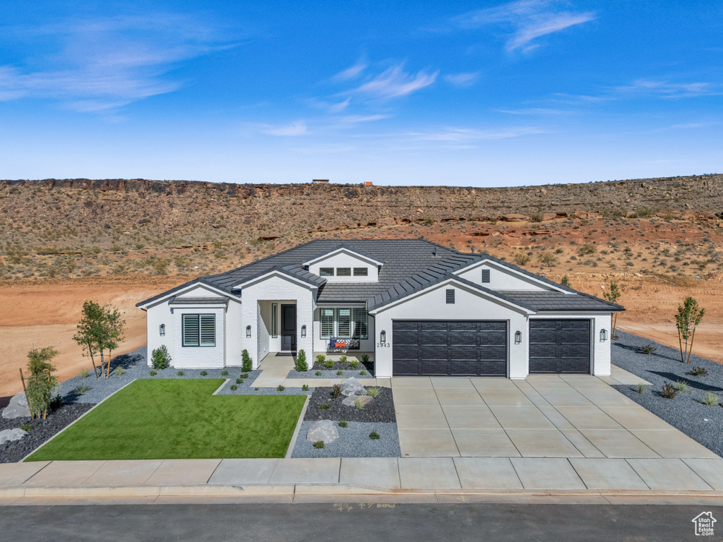 Ranch-style house with a garage, a front lawn, and covered porch