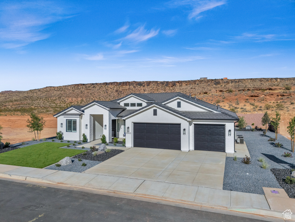 Single story home with a mountain view, a garage, and central air condition unit