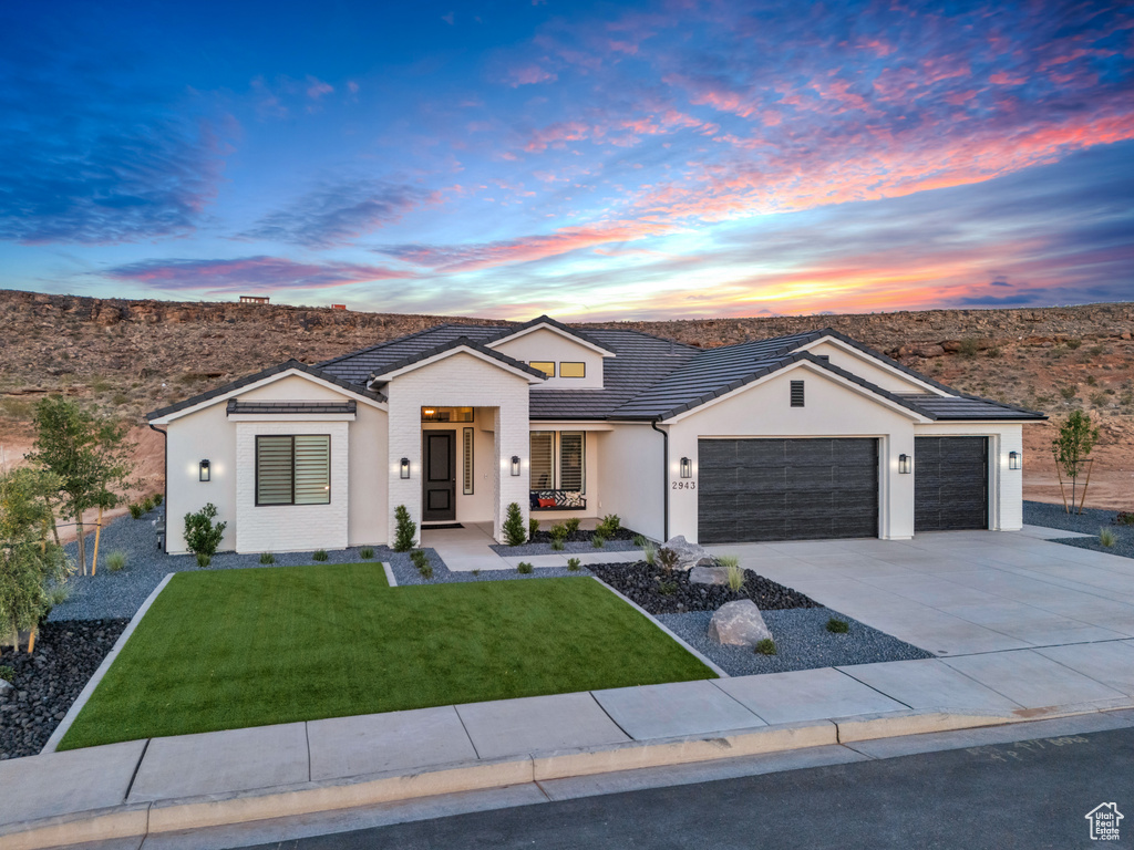 Ranch-style house with a garage and a yard