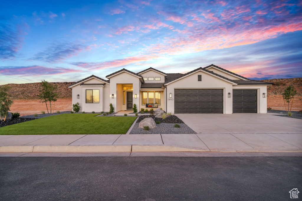 View of front of home with a lawn and a garage