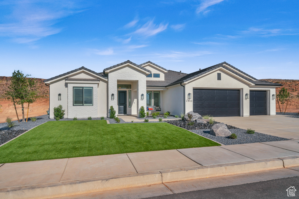 View of front of property with a garage and a front yard