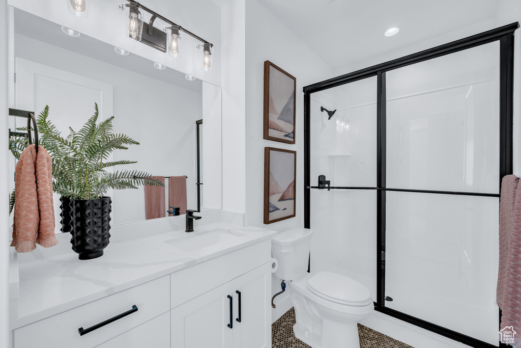 Bathroom with vanity, toilet, and an enclosed shower