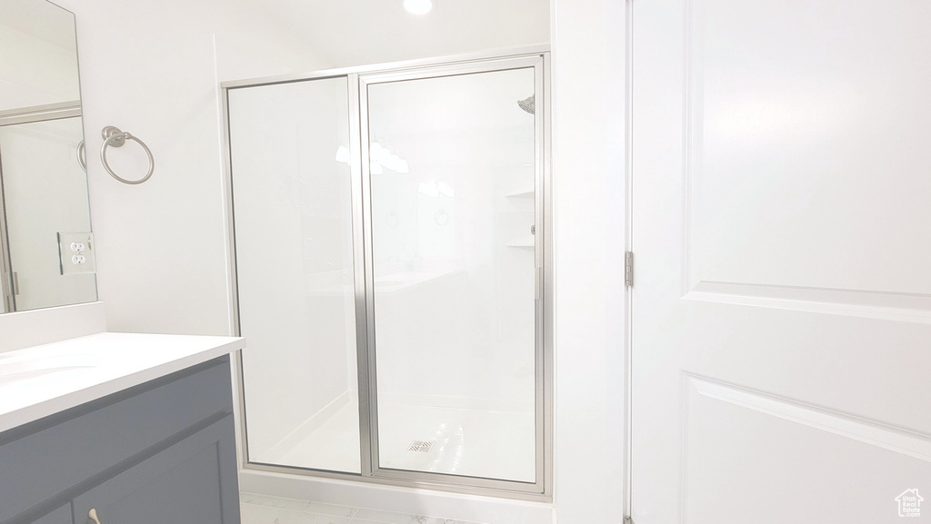 Bathroom featuring vanity and a shower with shower door