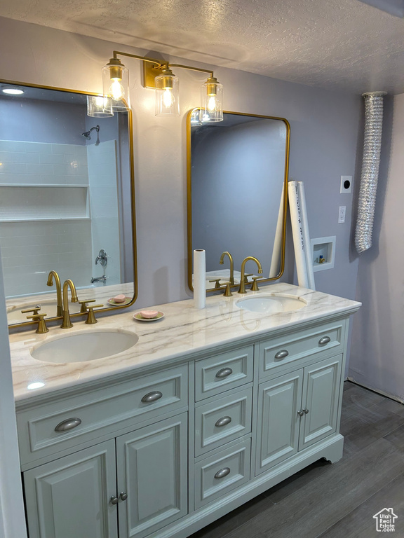 Bathroom with vanity, hardwood / wood-style floors, and a textured ceiling