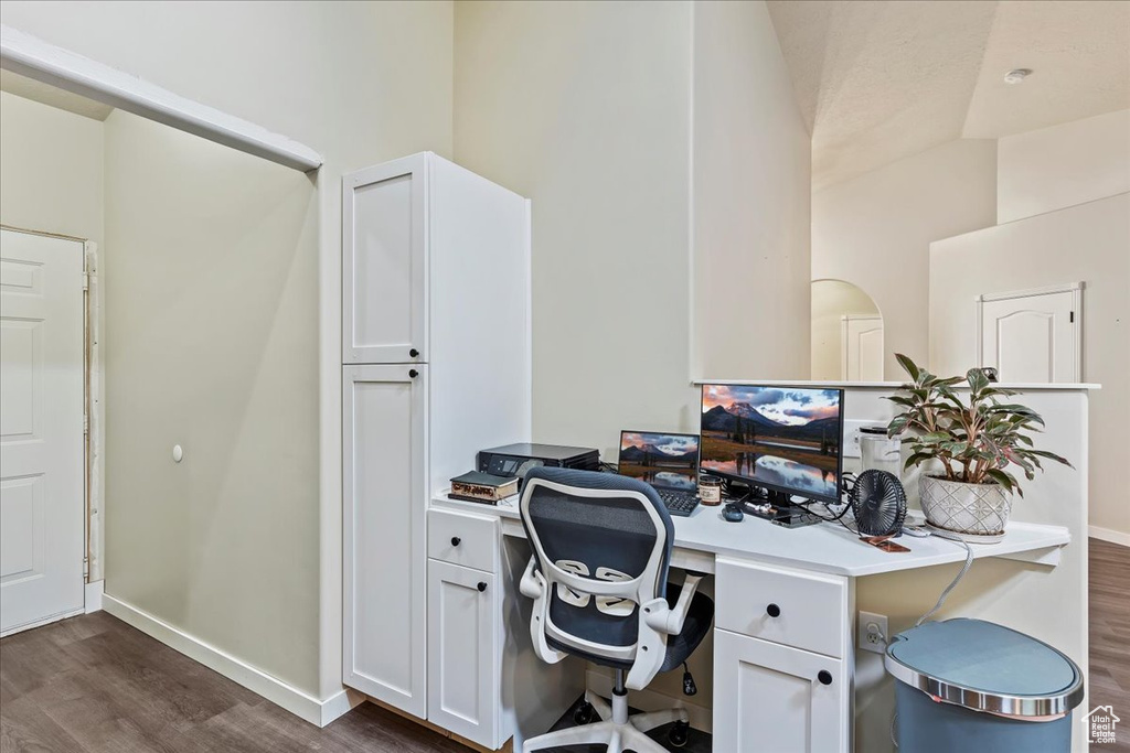 Home office with vaulted ceiling and dark hardwood / wood-style flooring