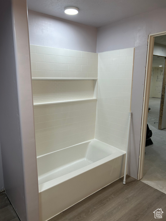 Bathroom featuring washtub / shower combination and hardwood / wood-style floors