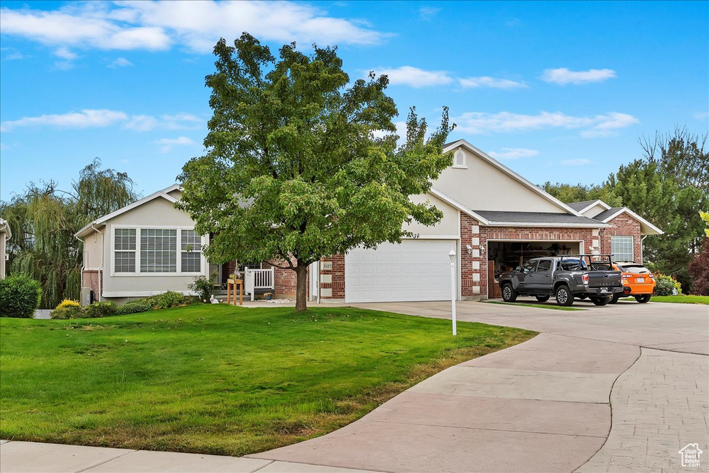 View of front facade featuring a front lawn and a garage