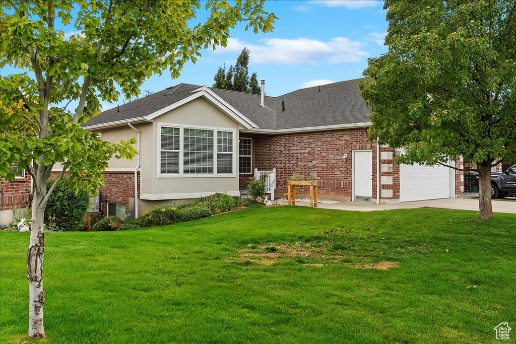 View of front of house with a front yard and a garage