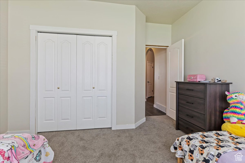 Bedroom featuring light colored carpet and a closet