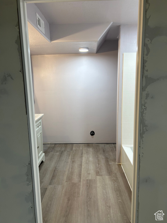 Bathroom with vanity, shower with separate bathtub, and hardwood / wood-style floors