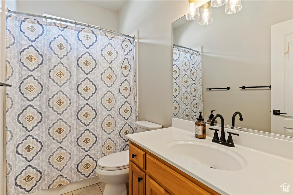 Bathroom with curtained shower, tile patterned flooring, vanity, and toilet