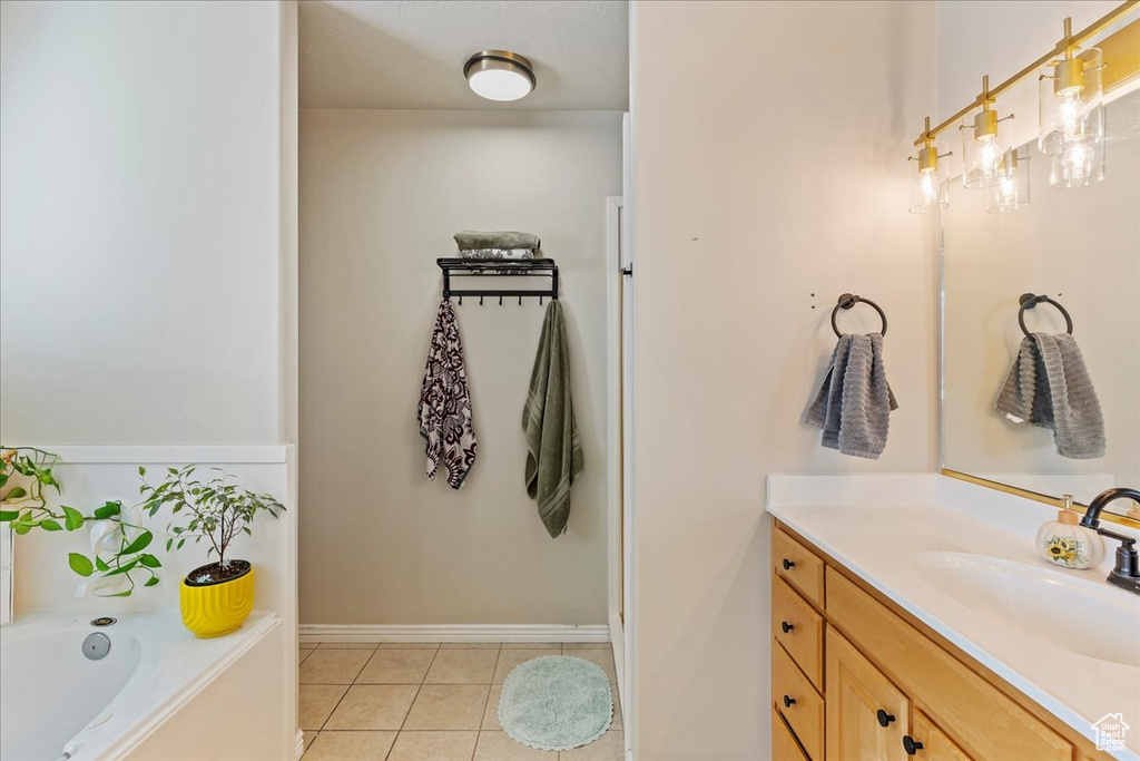 Bathroom featuring a bathing tub, tile patterned flooring, and vanity