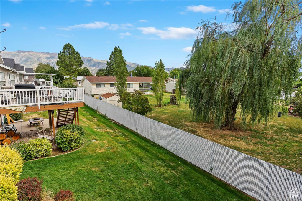 View of yard with a deck with mountain view