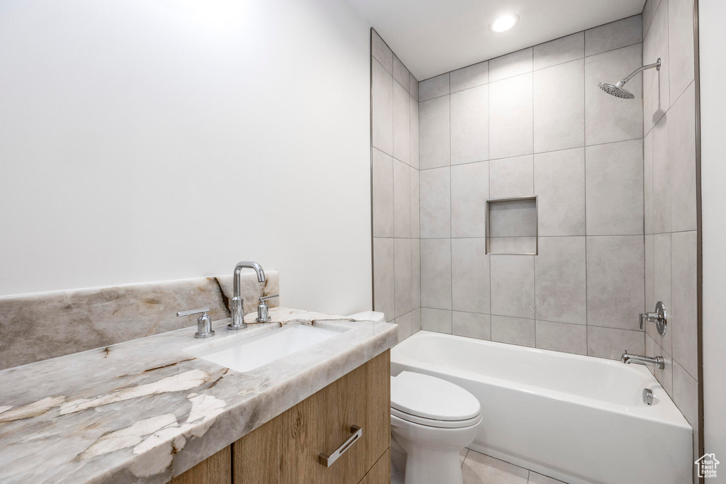 Full bathroom featuring tile patterned flooring, vanity, toilet, and tiled shower / bath combo