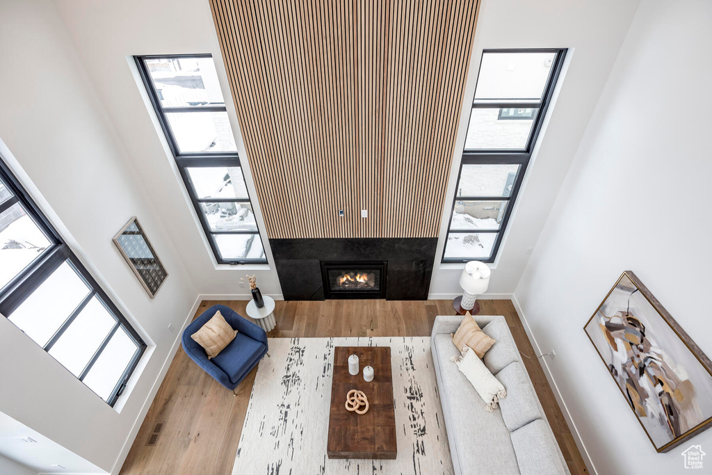 Living room featuring a high ceiling, hardwood / wood-style flooring, and a fireplace